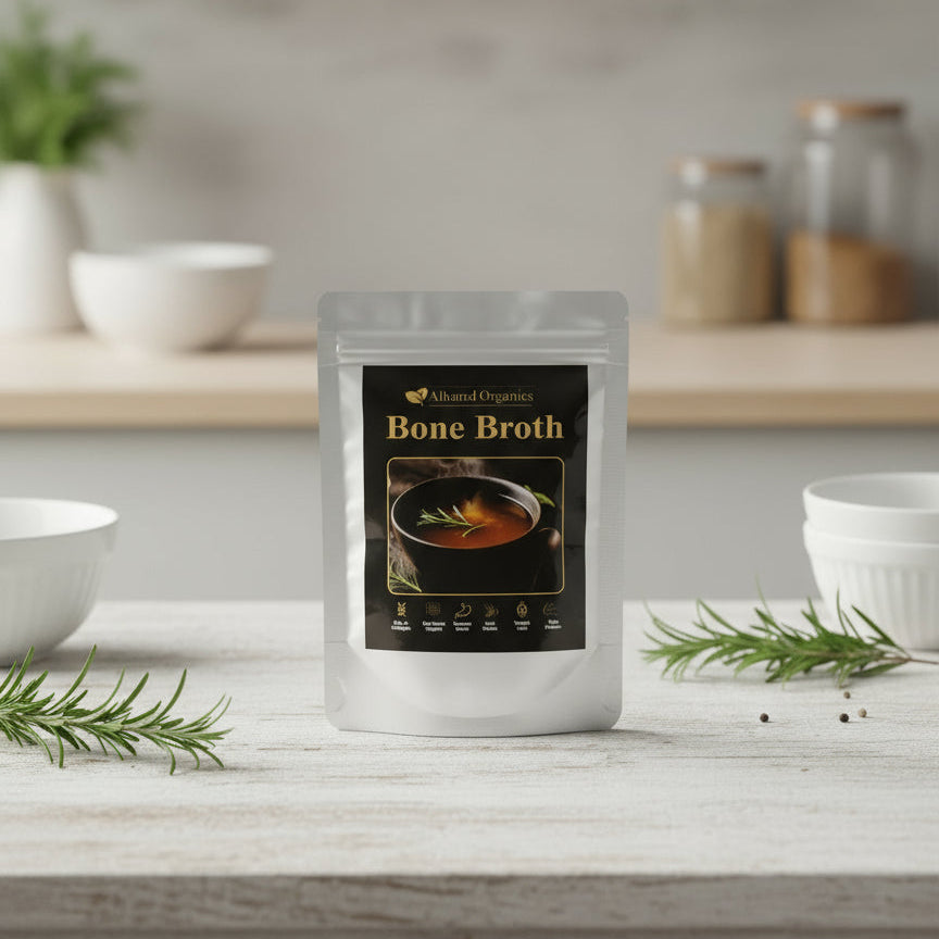 Package of Almond Organics Bone Broth on a kitchen counter with herbs and bowls in the background.